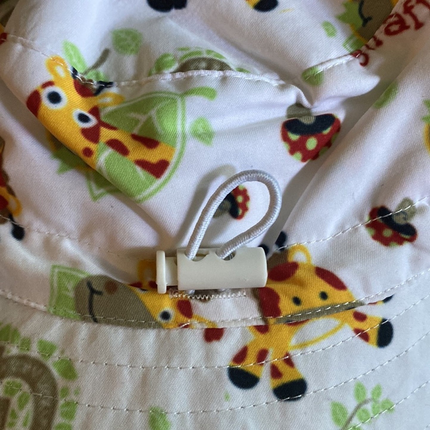 Close-up of a fabric with animal patterns and a white pull clip on a white background
