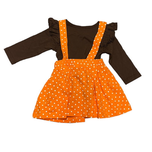 Back of Orange polka dot dress with ruffled brown sleeves on a white background