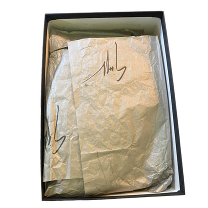 Box with tissue paper inside, featuring a signature.