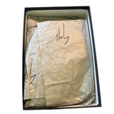 Box with tissue paper inside, featuring a signature.