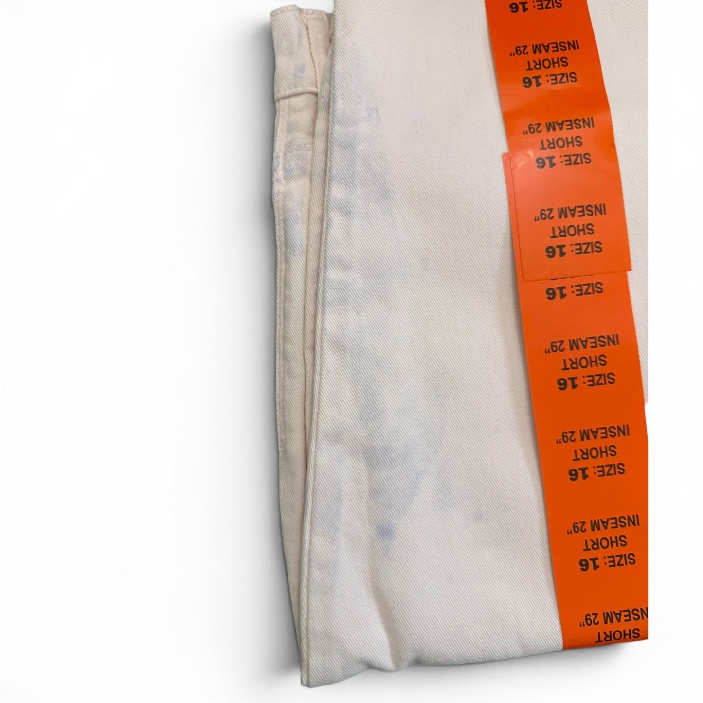 Pink jeans with blue issues on pants with orange size tags on a white background