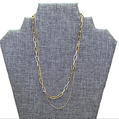 Gold chain necklace on a gray bust display