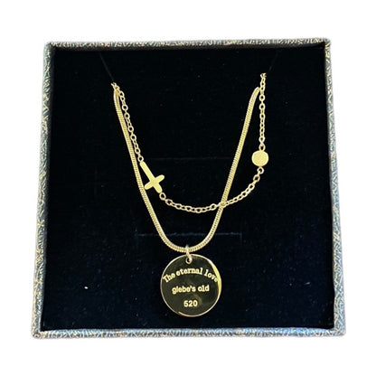 Gold tone necklace with a pendant on a black display box