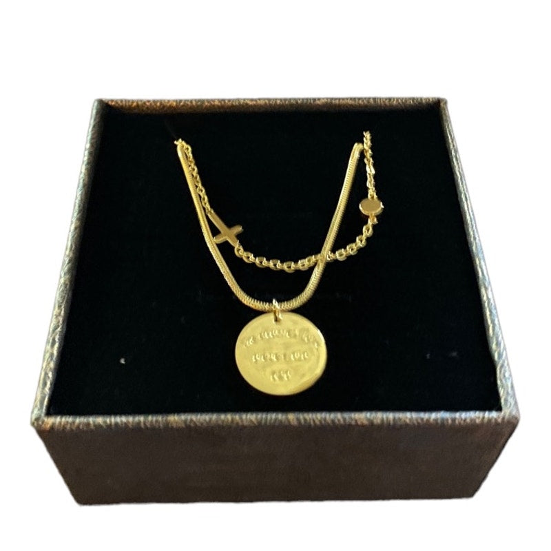 Gold tone necklace with a pendant in a black jewelry box