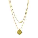 Layered gold tone necklaces with pendants on a white background