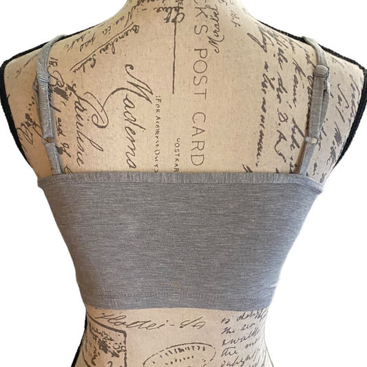 Gray top back on a mannequin with vintage-style text pattern