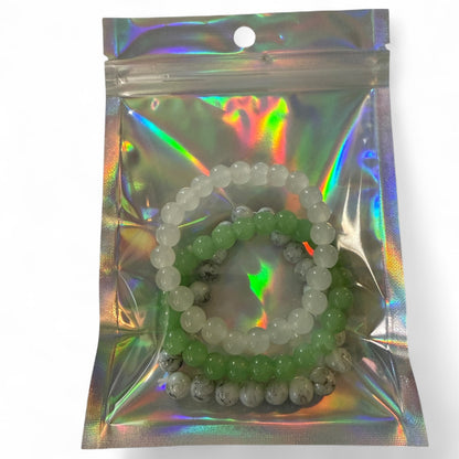 Set of beaded bracelets in a reflective packaging on a white background