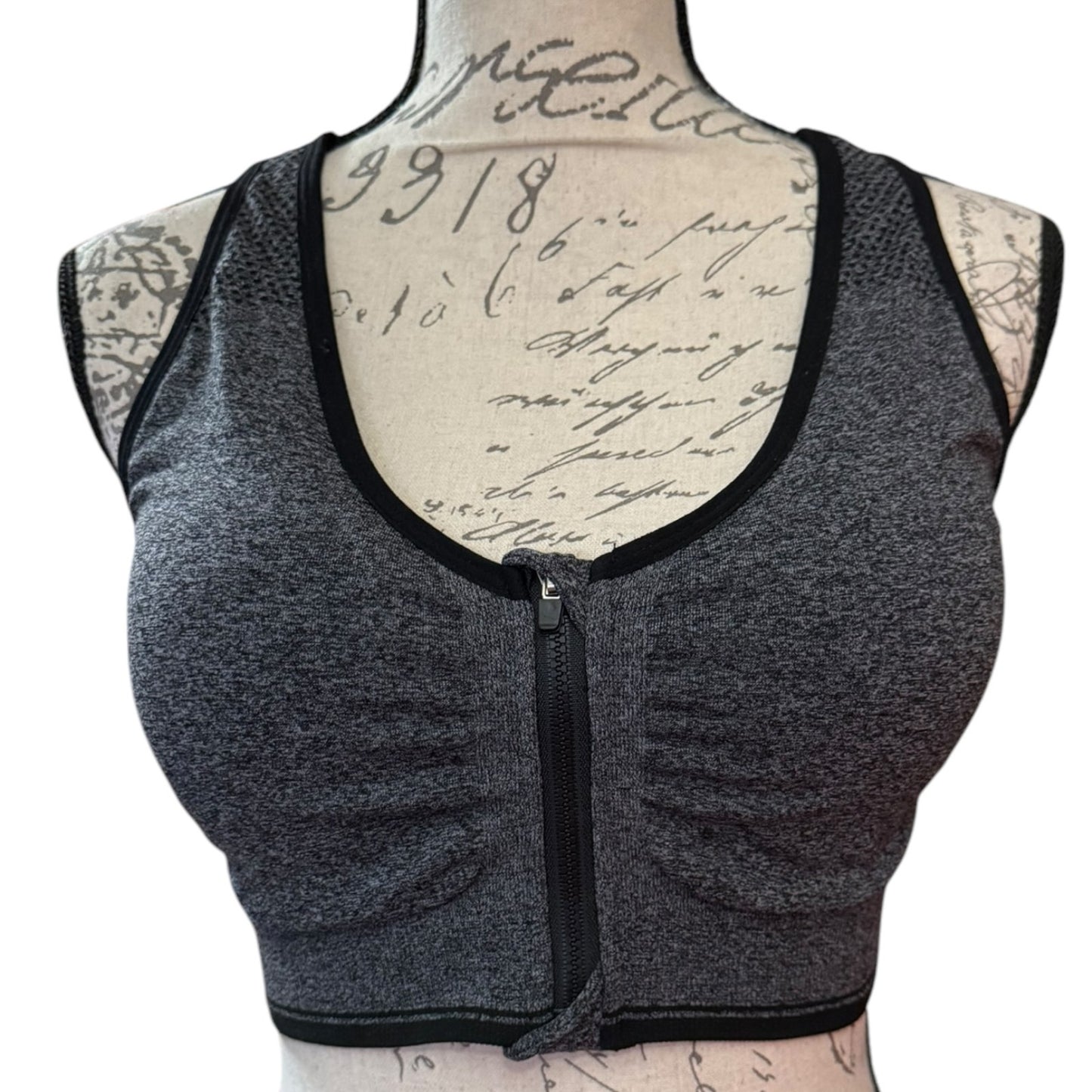 Front of Gray sports bra with black trim on a mannequin with tattooed arms.