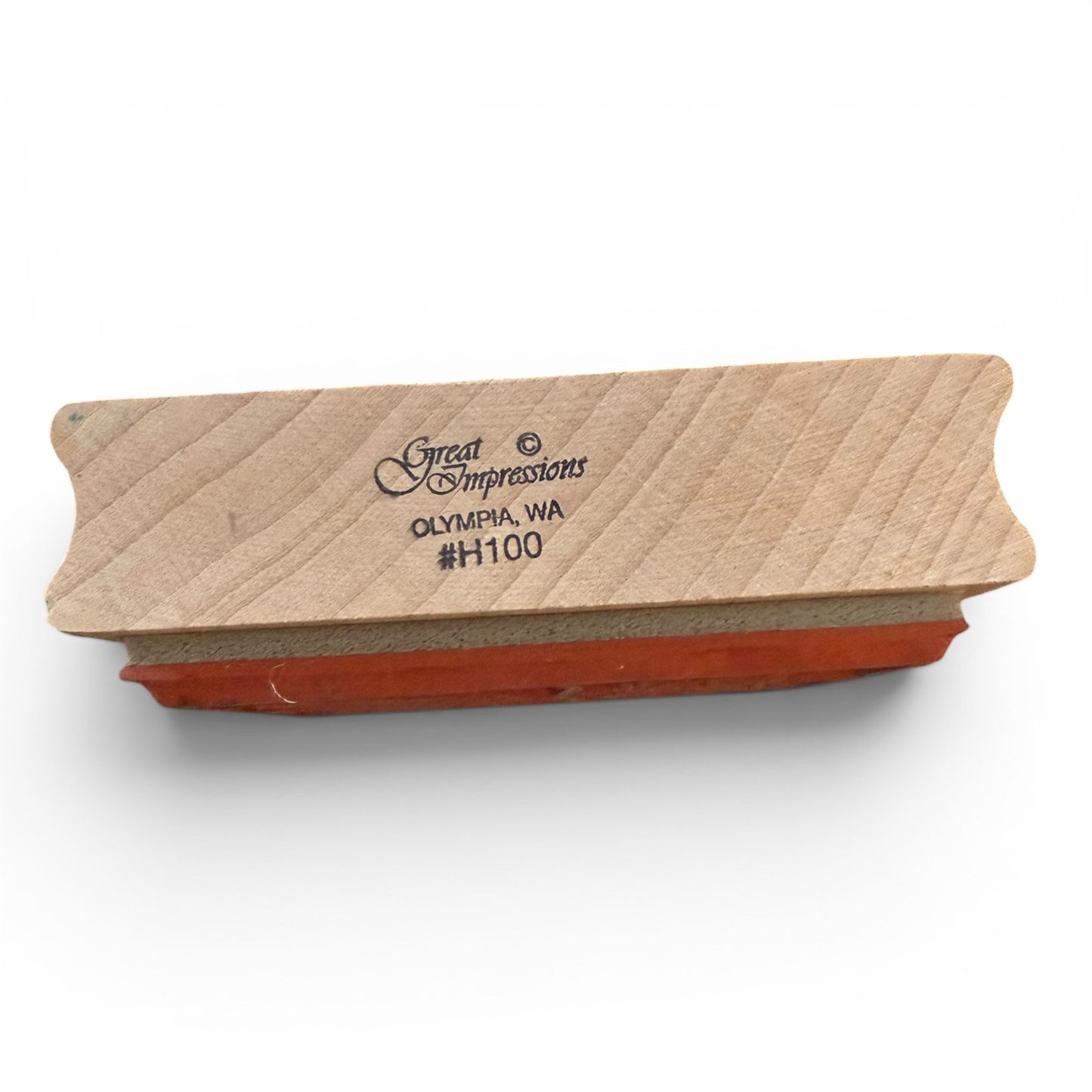 Wooden stamp block with red ink pad on a white background
