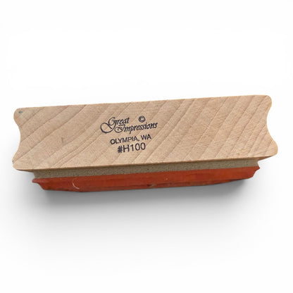Wooden stamp block with red ink pad on a white background