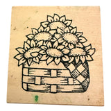 Rubber stamp with a design of sunflowers in a basket on a wooden block.