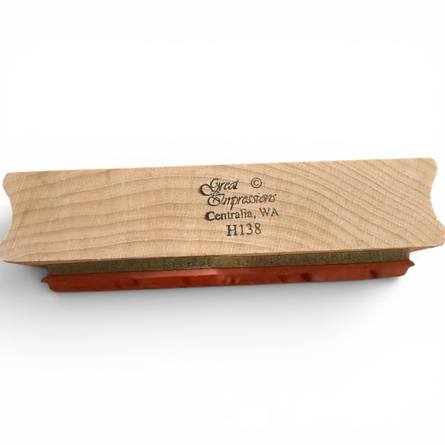 Wooden stamp with red ink pad on a white background