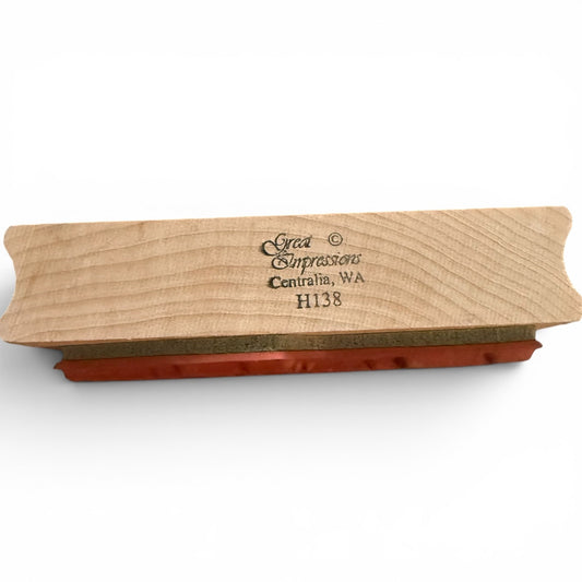 Wooden stamp with red ink pad on a white background
