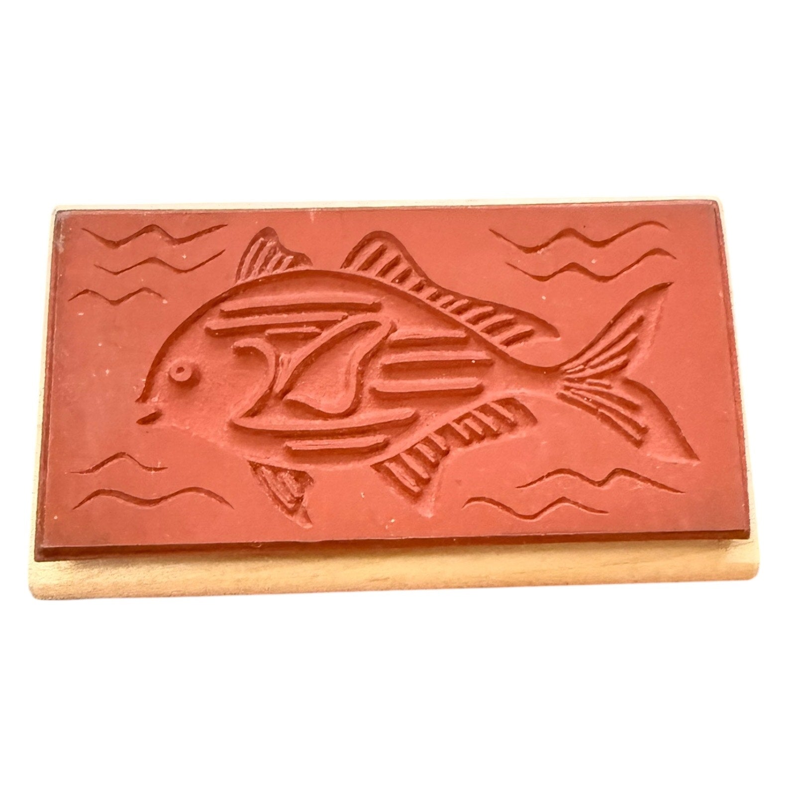 Red rectangular stamp with fish design on a white background