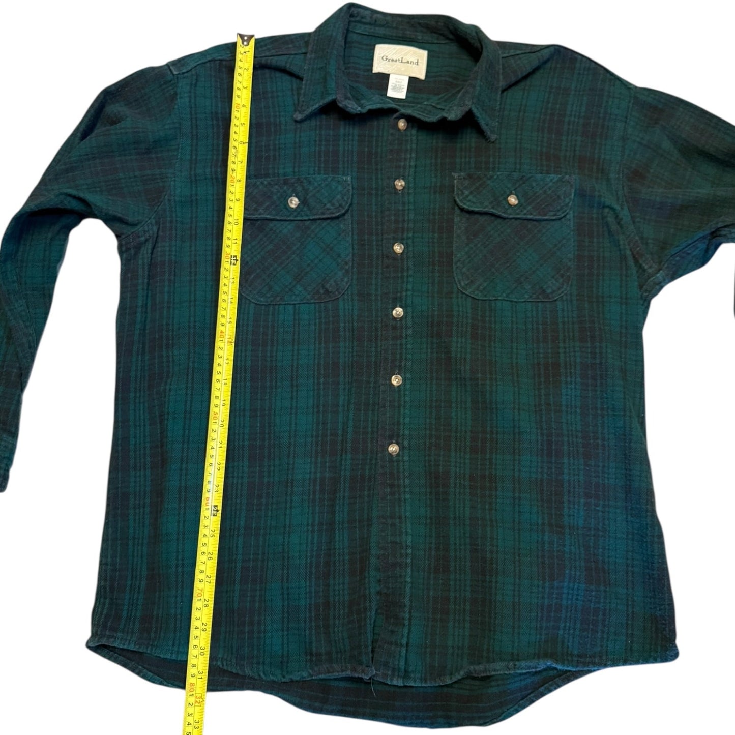 Green plaid shirt with a measuring tape  length on a white background