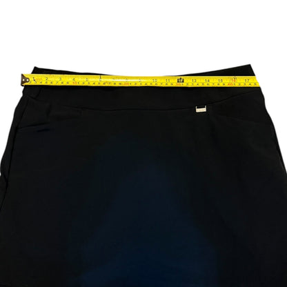 Black skort with a yellow measuring tape around the waist on a white background