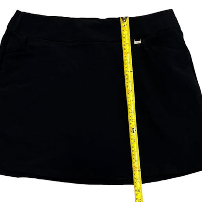 Black skort with a yellow measuring tape on a white background