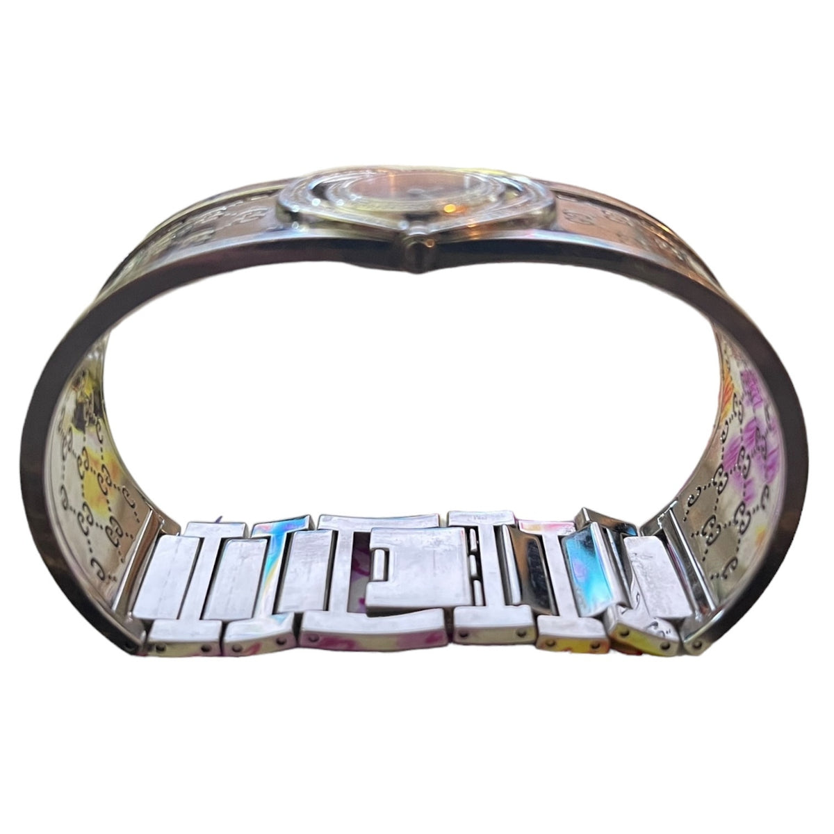 A Gucci metal bracelet watch with a silver-tone band featuring the brand's signature GG monogram pattern shown from the side, shown against a plain white background.