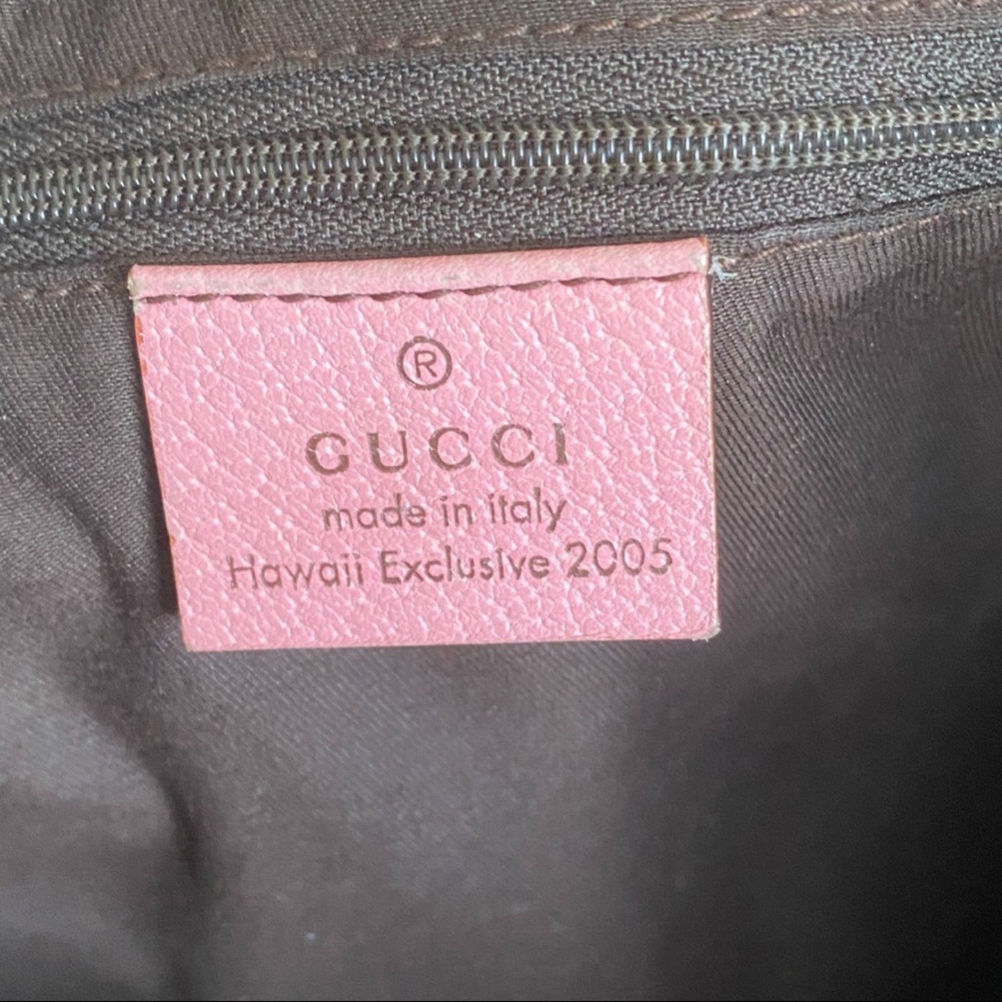 Pink Gucci label on a dark fabric background