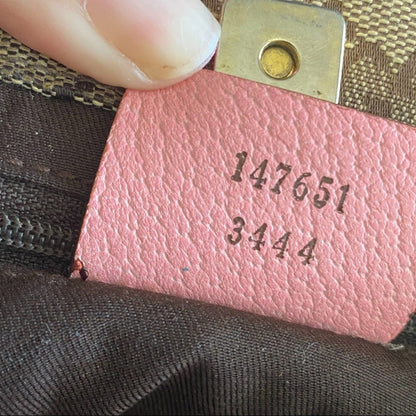 Pink leather tag with serial numbers on a textured surface