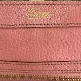 Gucci in gold on pink purse