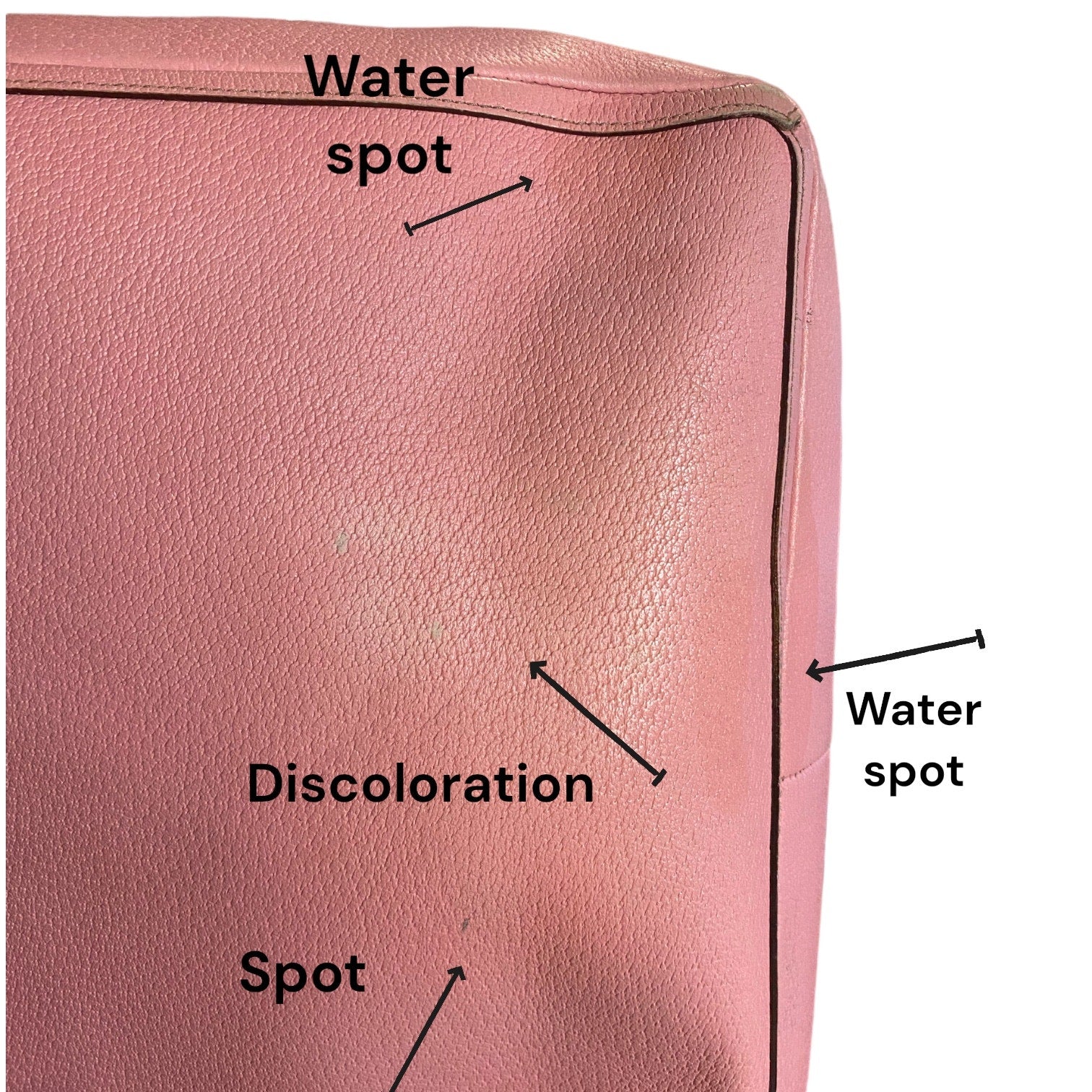 Pink leather surface with labeled water spots, discoloration, and spots.