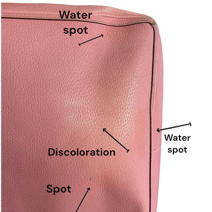 Pink leather surface with labeled water spots, discoloration, and spots.