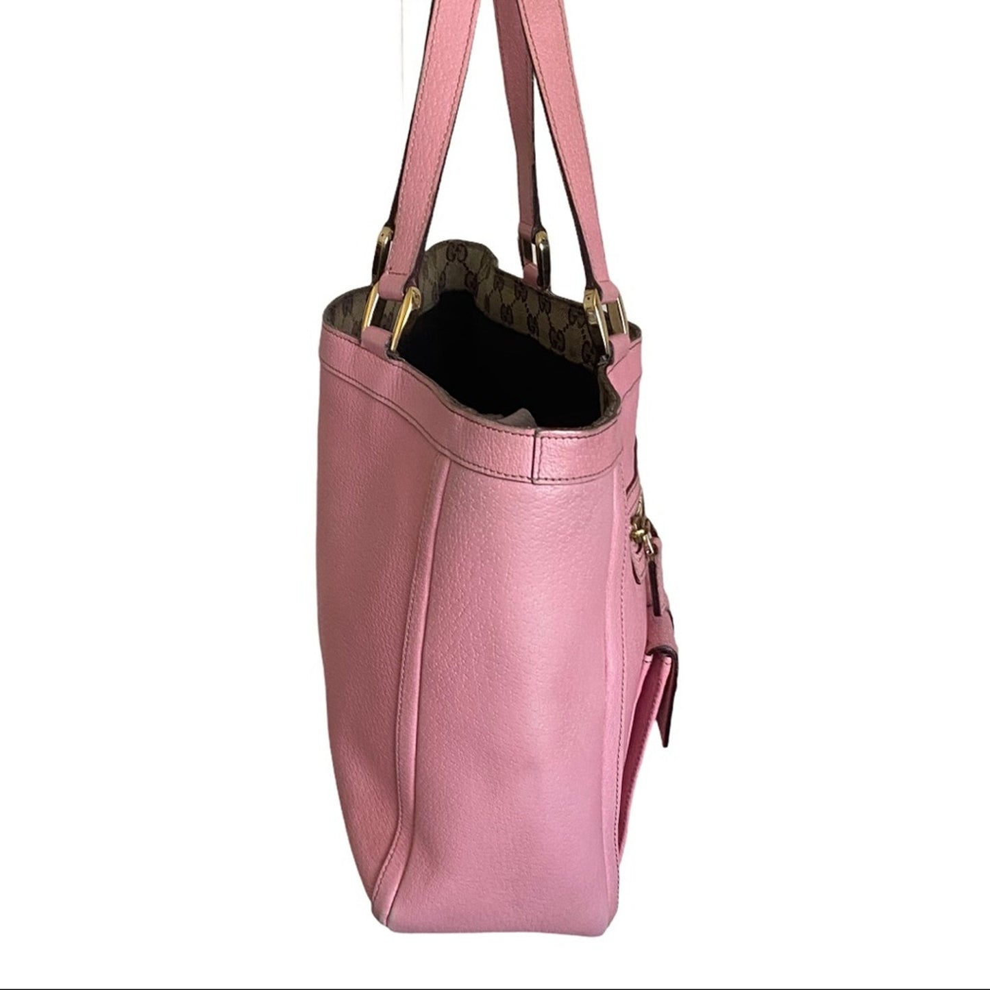 Side of Pink handbag with gold accents on a white background