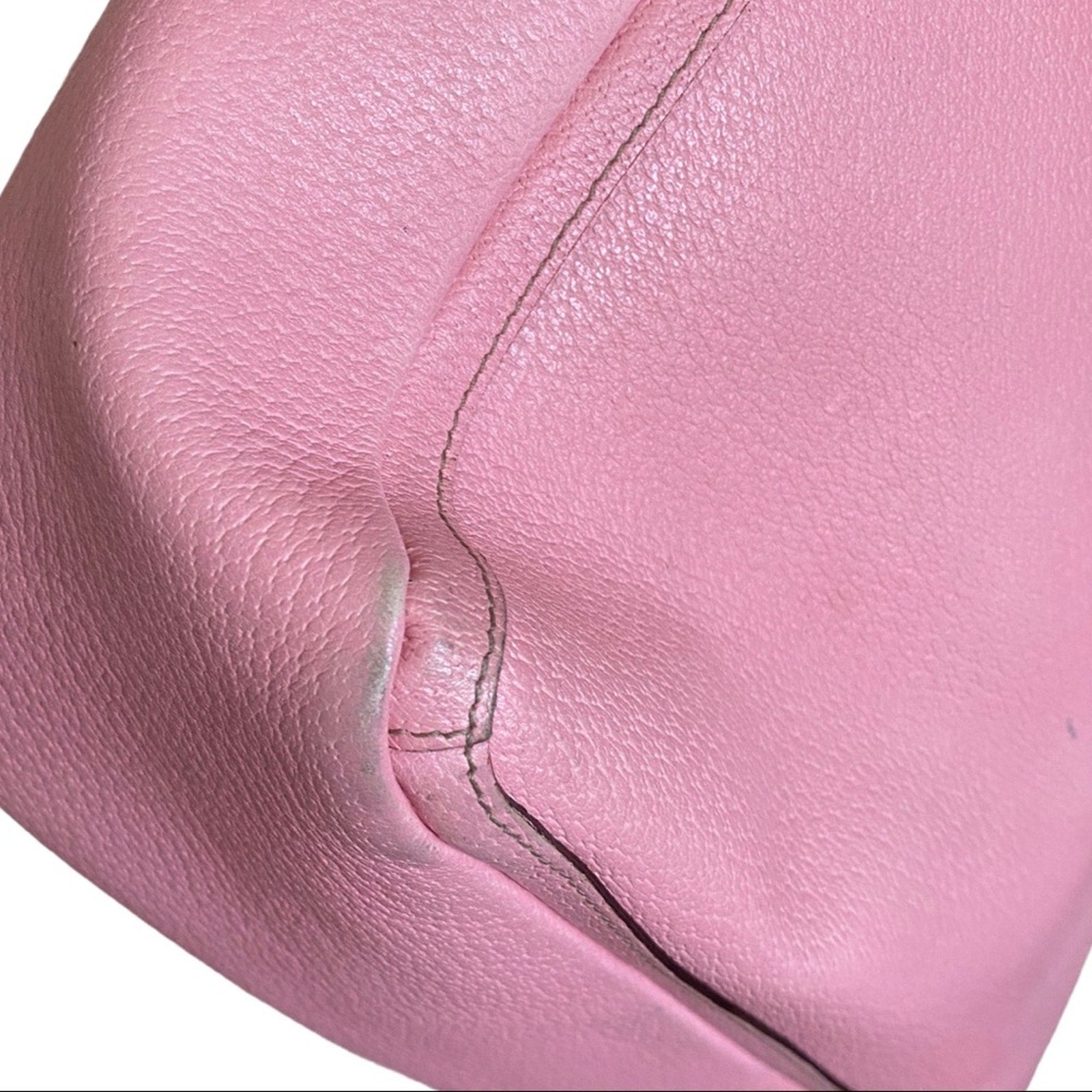 Close-up of pink leather corner with a visible seam on a white background