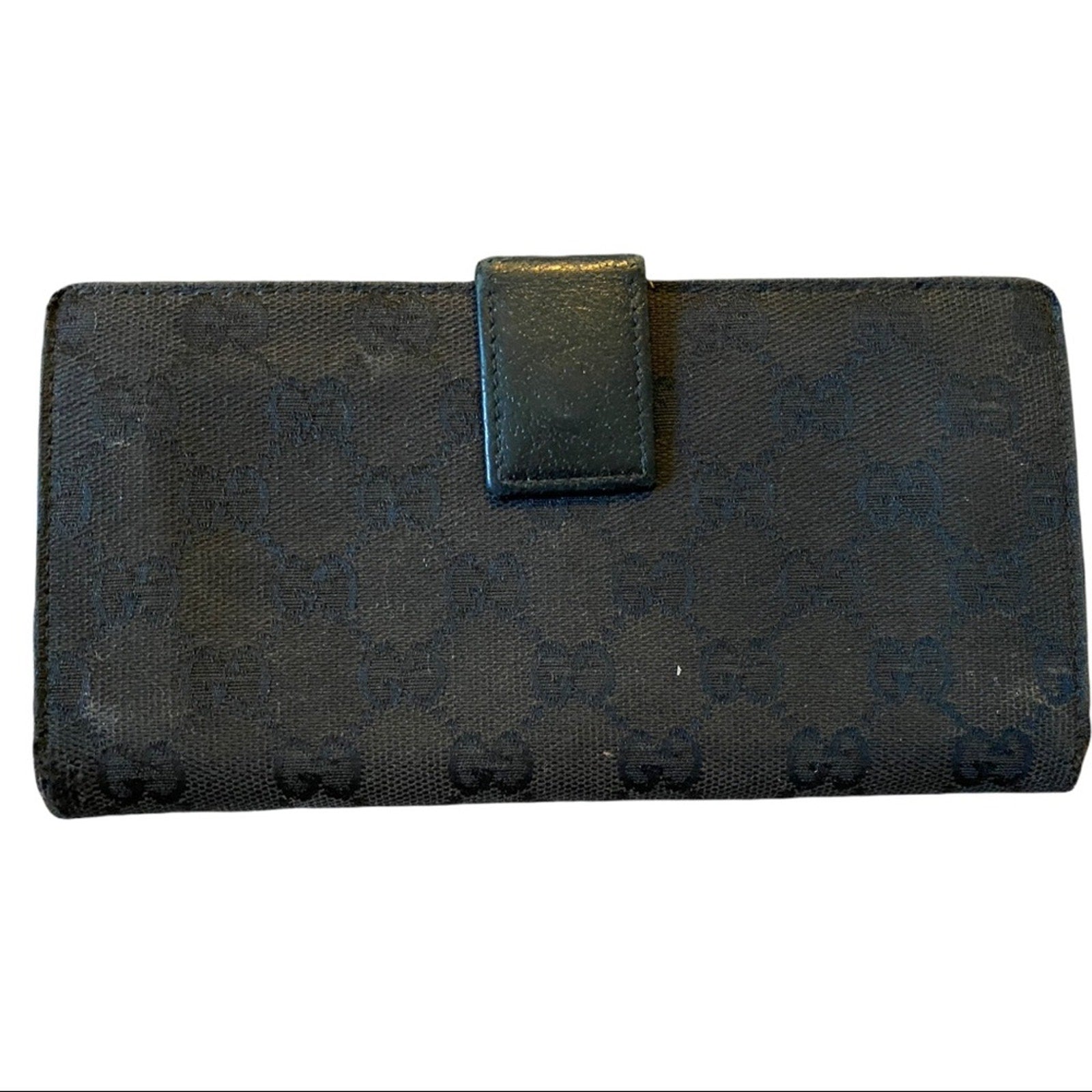 Black textured wallet with a flap on a white background