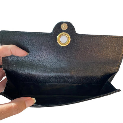 Interior of coin pocket on black Gucci wallet held by a hand on a white background