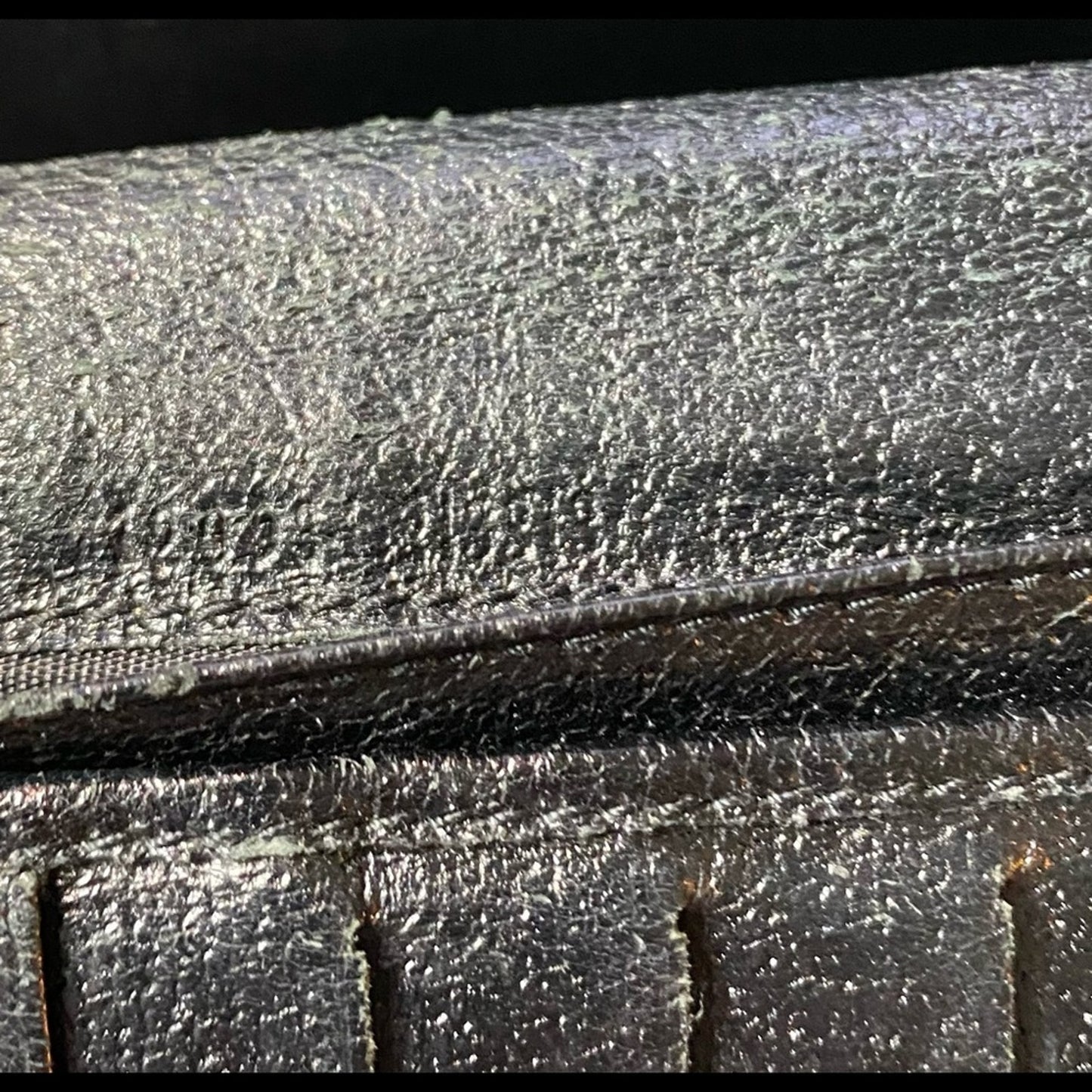 Close-up of a black leather surface with light numbers fading