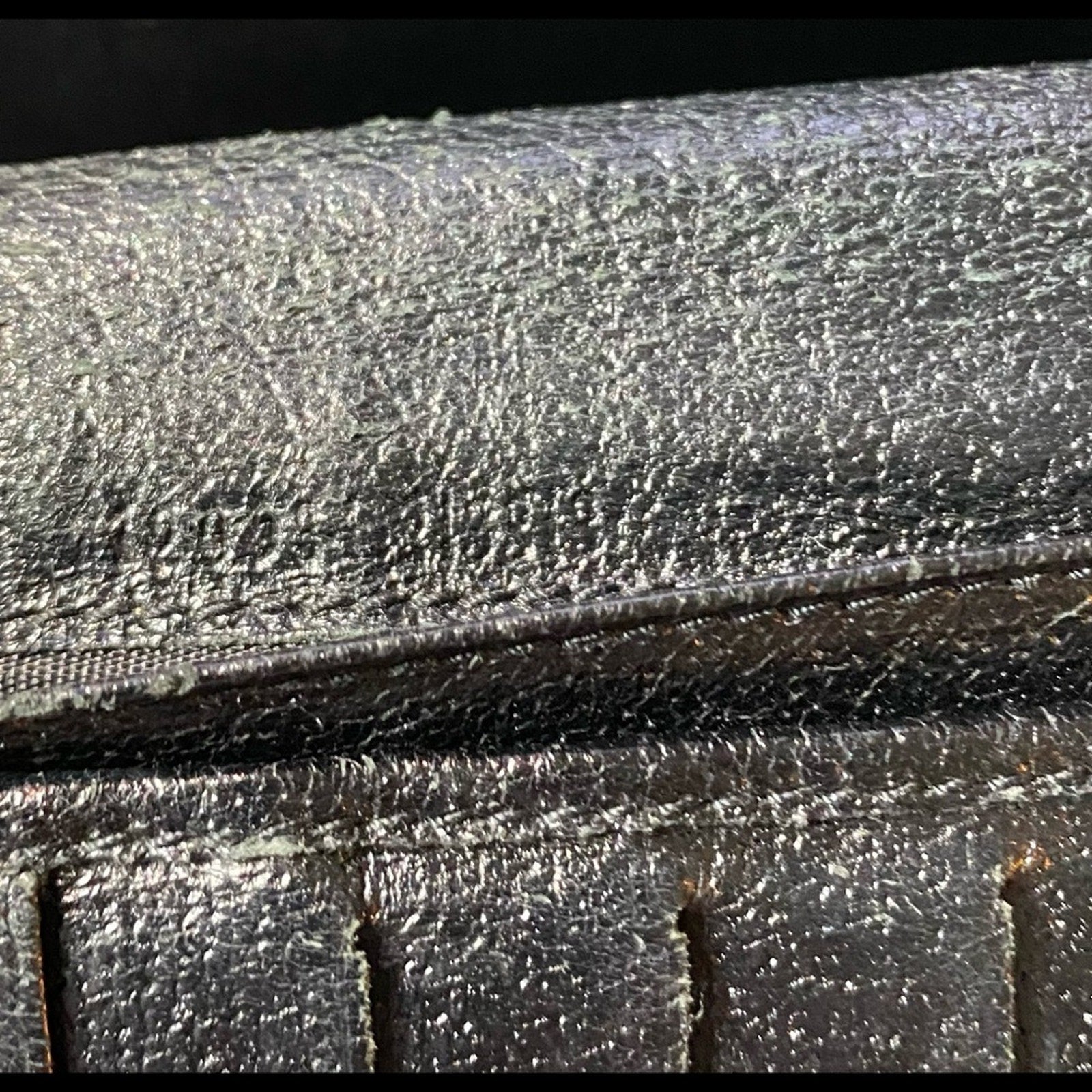 Close-up of a black leather surface with light numbers fading