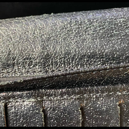 Close-up of a black leather surface with light numbers fading