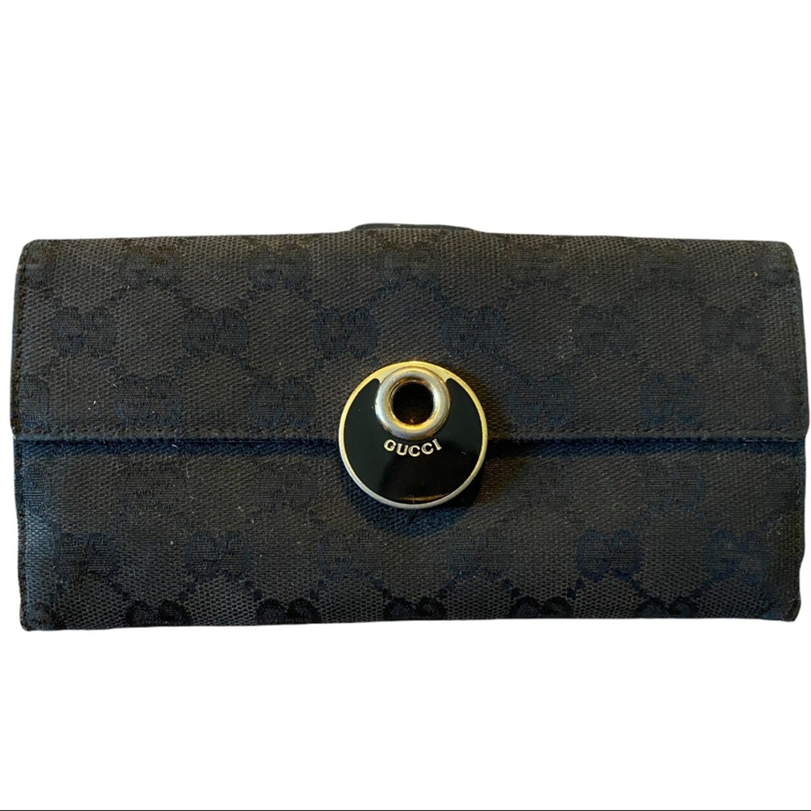 Black Gucci wallet with a circular logo on a white background