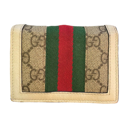 Gucci wallet with GG pattern and red and green stripes on a beige background