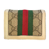 Gucci wallet with GG pattern and red and green stripes on a beige background