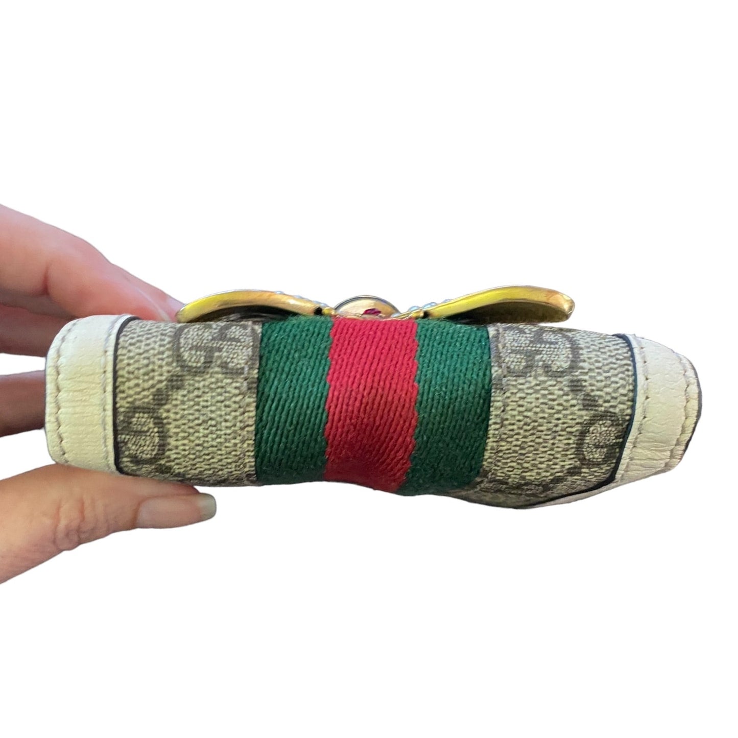 Wallet with green and red stripes held by a hand on a white background