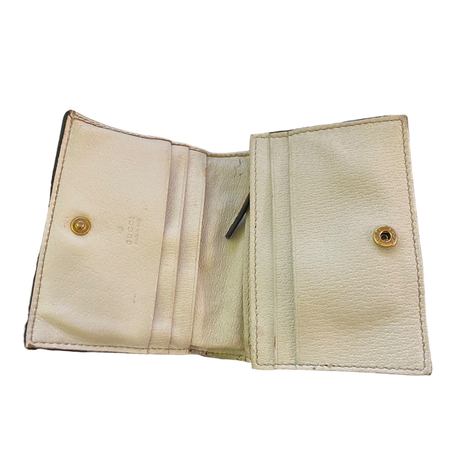 Beige leather wallet interior with gold buttons on a white background