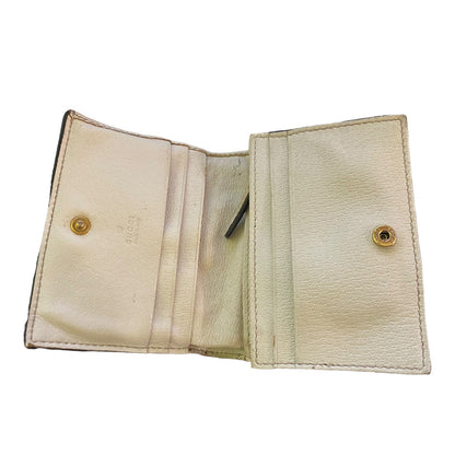 Beige leather wallet interior with gold buttons on a white background