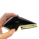 Hand holding an open beige wallet against a white background