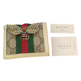 Gucci wallet with bee emblem and packaging on a white background