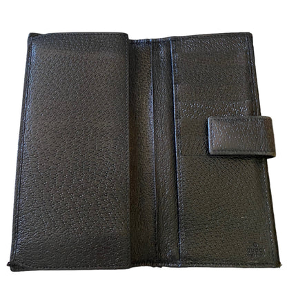 Interior of a black textured leather wallet shown open against a plain white background, displaying its interior compartments and a small tab closure on the right side.