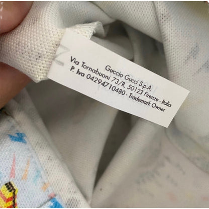 Close-up of a Gucci label on a piece of fabric with colorful patterns.