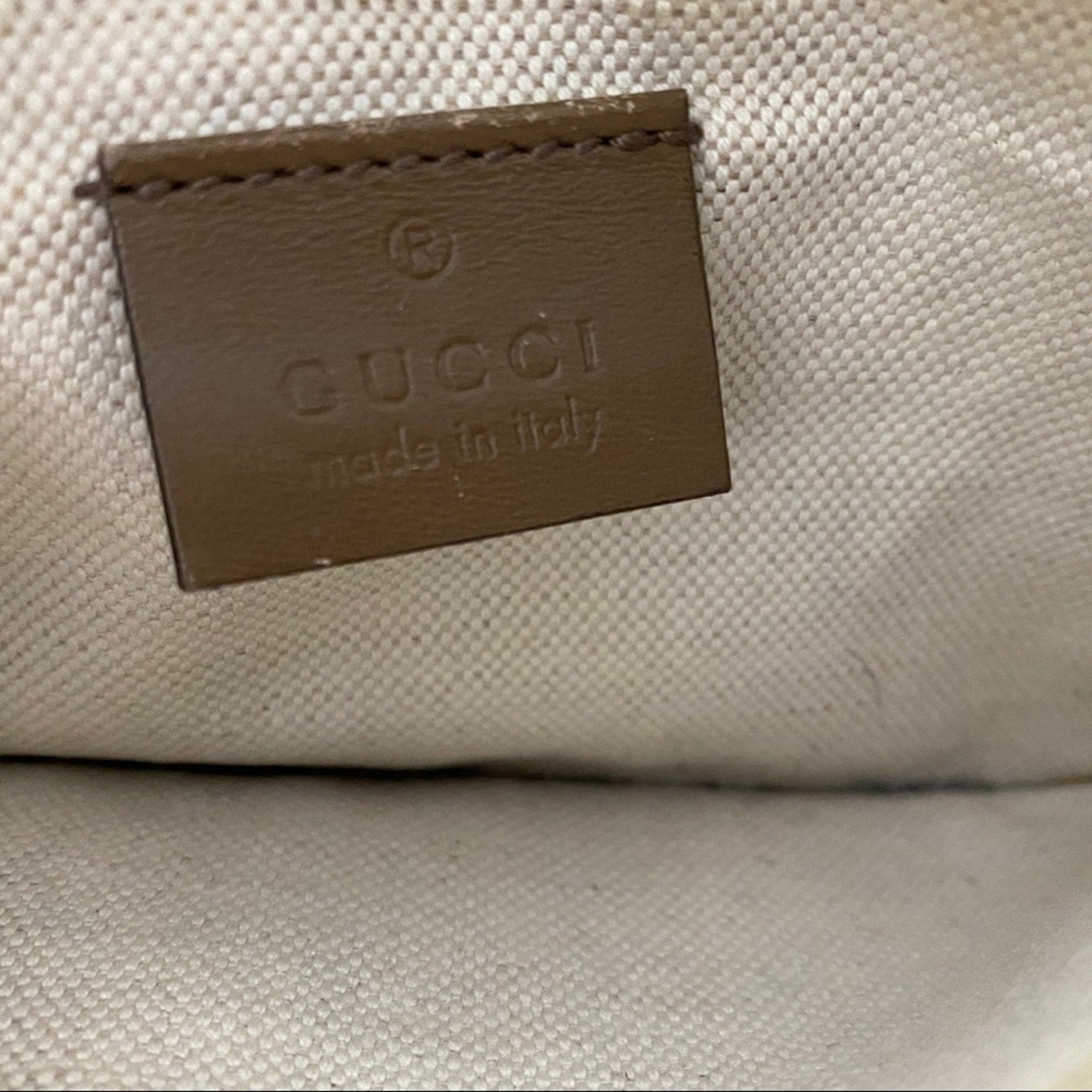 Close-up of a Gucci logo on a beige fabric background