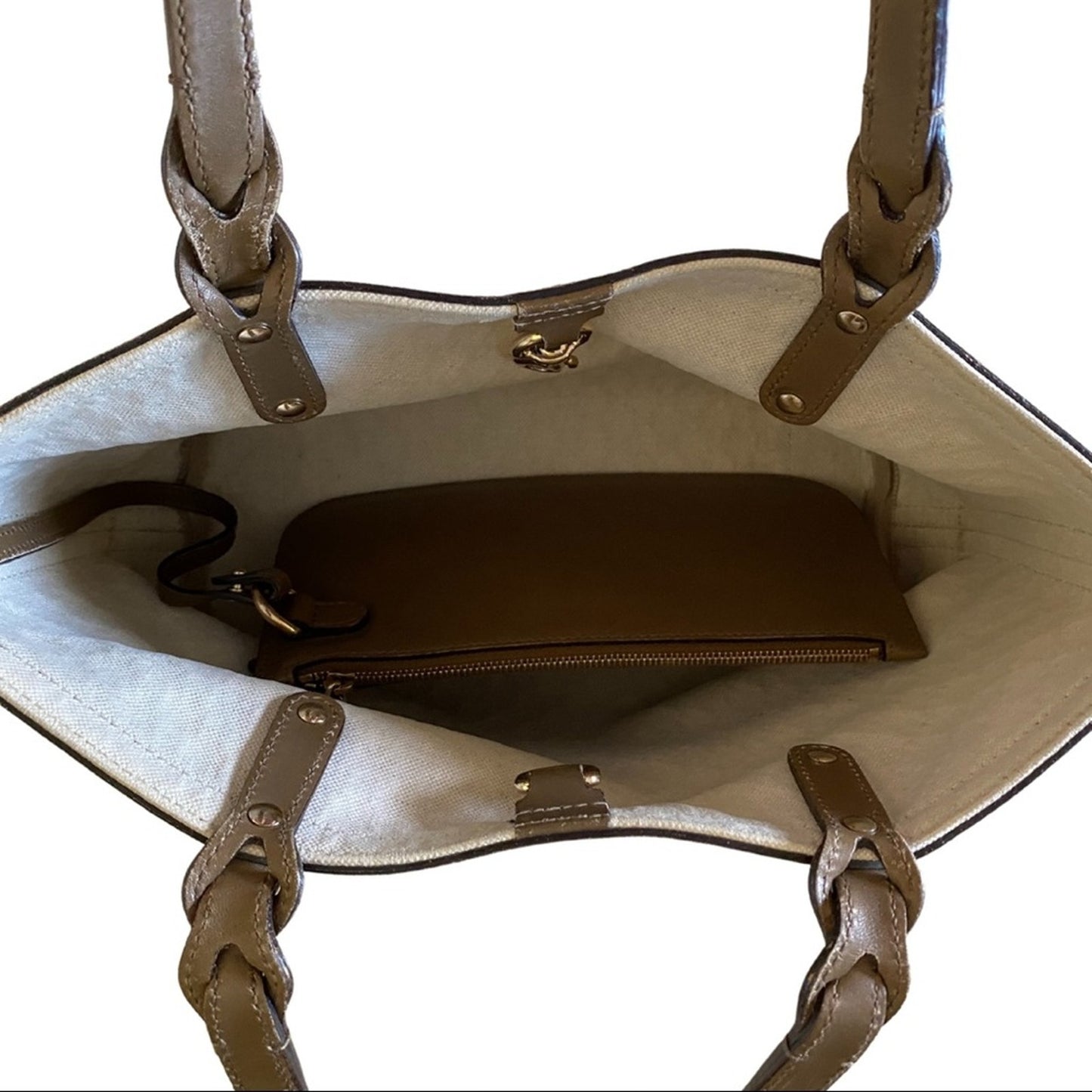 Open beige handbag with a brown wallet inside on a white background