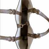 Close-up of top of a beige handbag with brown leather straps on a white background