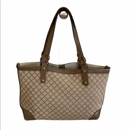 Back of Beige and brown patterned handbag with a matching handle on a white background