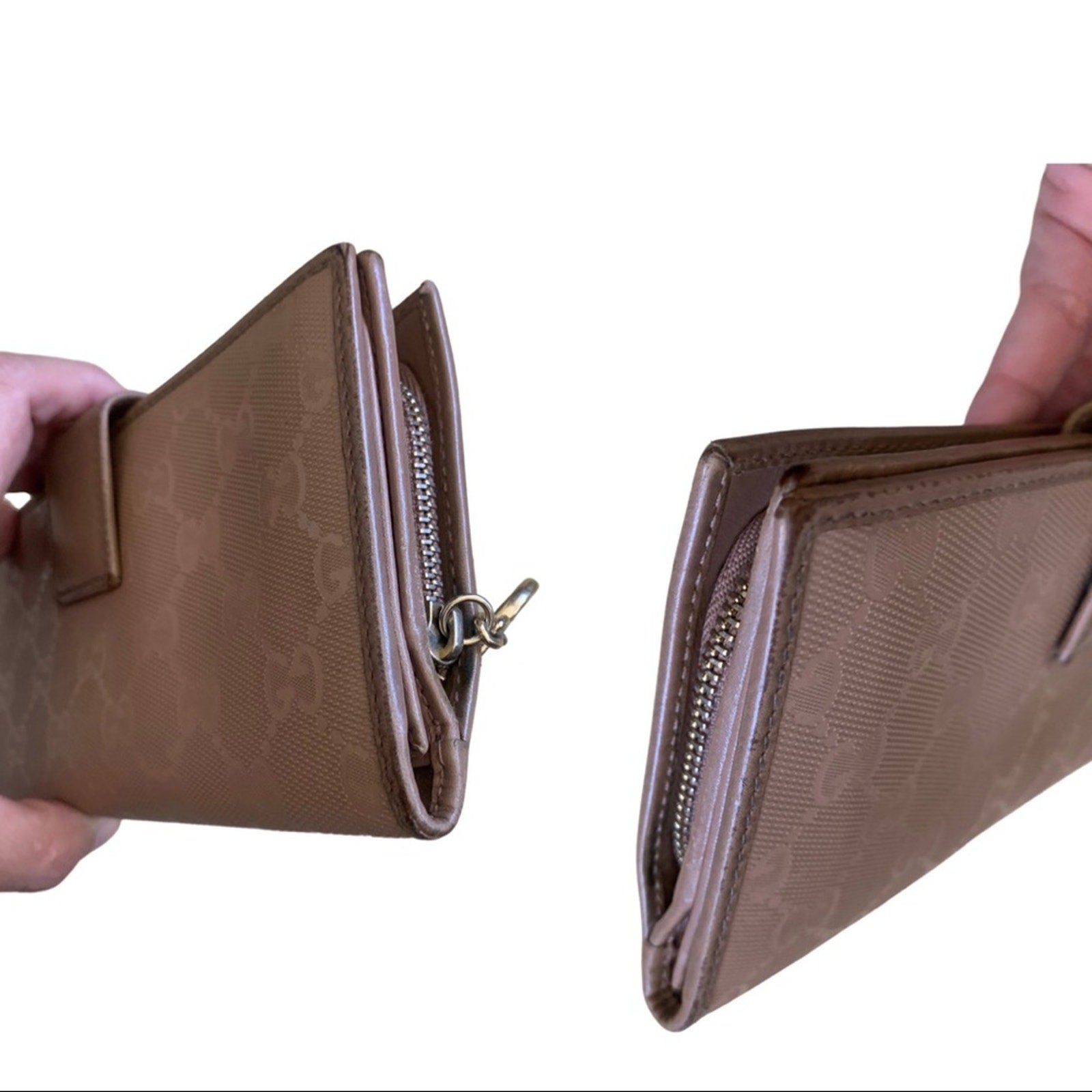 Pink Gucci wallet edges with a pattern held by a hand on a white background