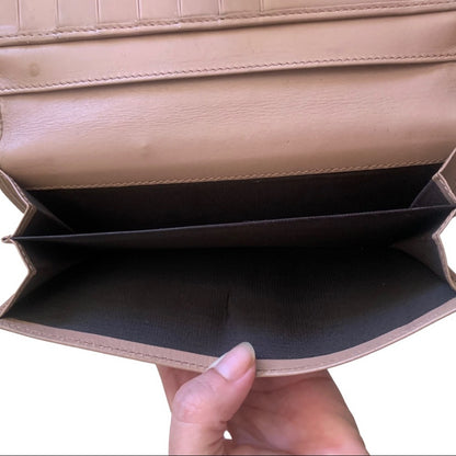 Close-up interior of a pink wallet with a black interior, held by a hand.